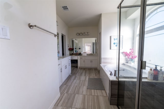 bathroom featuring vanity and independent shower and bath