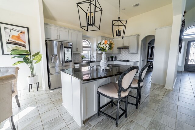 kitchen featuring a center island, stainless steel appliances, hanging light fixtures, and gray cabinetry