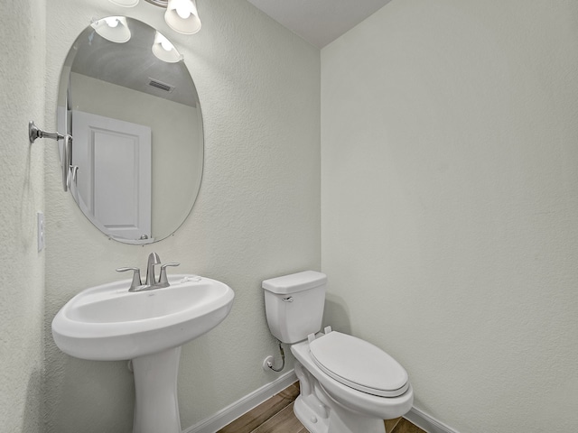 bathroom featuring hardwood / wood-style floors and toilet