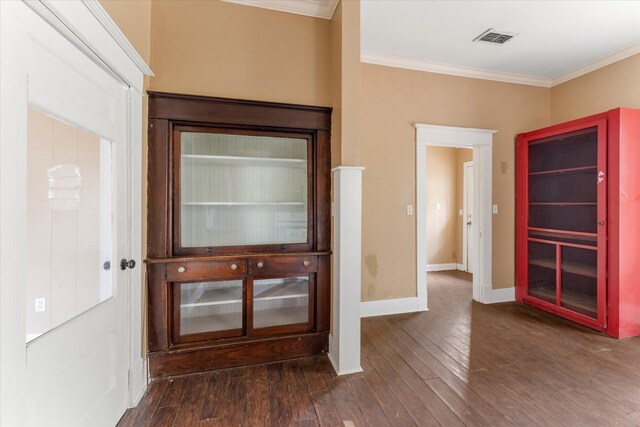 interior space with ornamental molding and dark wood-type flooring