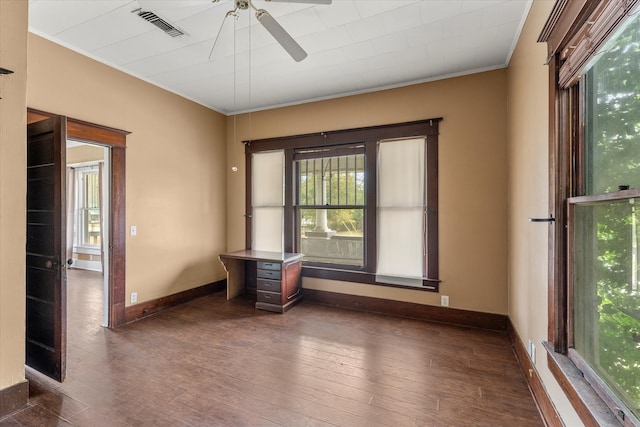 spare room featuring ceiling fan, dark wood-type flooring, and ornamental molding