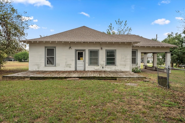 back of property with a wooden deck and a yard