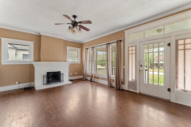 unfurnished living room featuring a textured ceiling, dark hardwood / wood-style flooring, ceiling fan, and ornamental molding