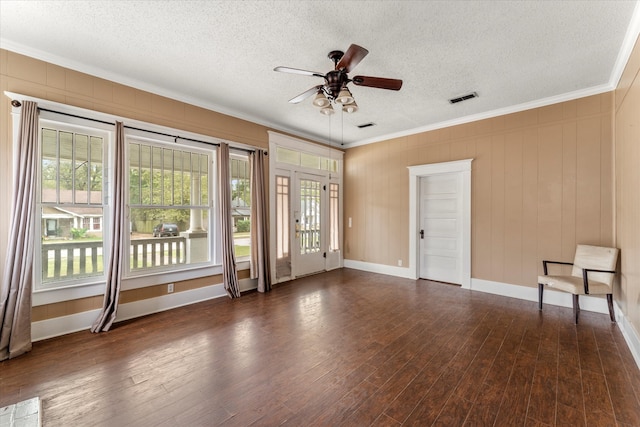 empty room with ceiling fan, dark hardwood / wood-style flooring, ornamental molding, and a textured ceiling