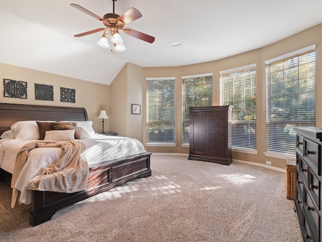 carpeted bedroom with ceiling fan and vaulted ceiling