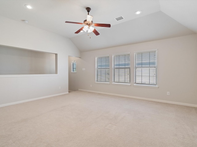 carpeted spare room with ceiling fan and vaulted ceiling