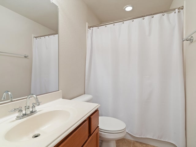 bathroom with toilet, vanity, and tile patterned floors