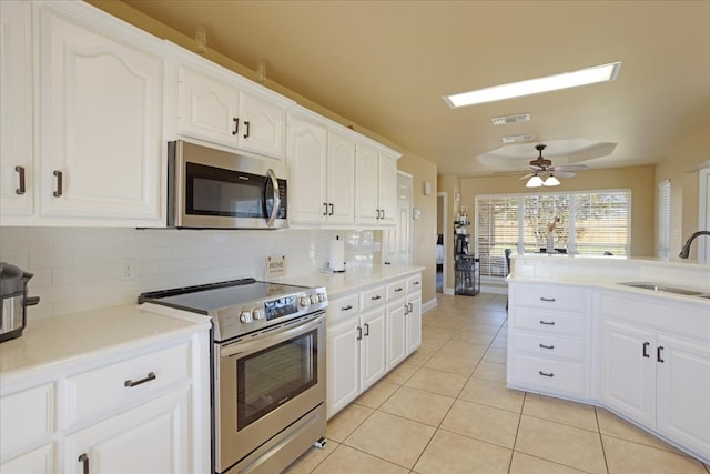 kitchen with white cabinets, appliances with stainless steel finishes, backsplash, and sink