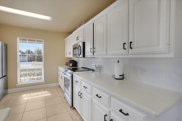 kitchen featuring tasteful backsplash, white cabinetry, light tile patterned floors, and stainless steel appliances