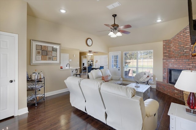 living room featuring dark hardwood / wood-style floors, ceiling fan, lofted ceiling, and a fireplace