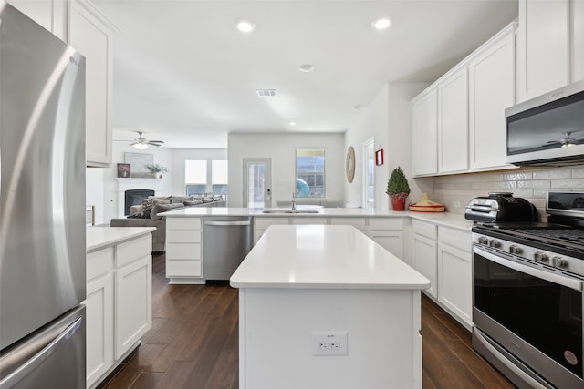 kitchen featuring white cabinetry, appliances with stainless steel finishes, a center island, and tasteful backsplash