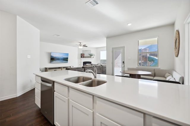 kitchen featuring ceiling fan, sink, dishwasher, white cabinets, and dark hardwood / wood-style floors