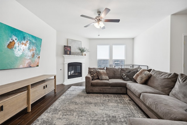 living room featuring ceiling fan and dark wood-type flooring