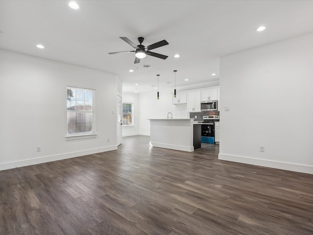 unfurnished living room with ceiling fan, dark hardwood / wood-style flooring, and sink