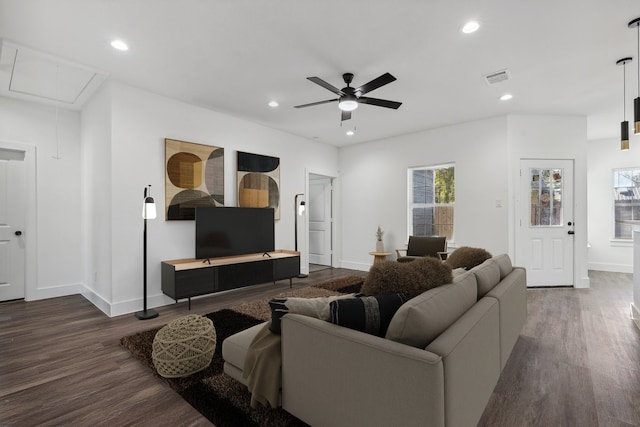 living room featuring ceiling fan and dark wood-type flooring