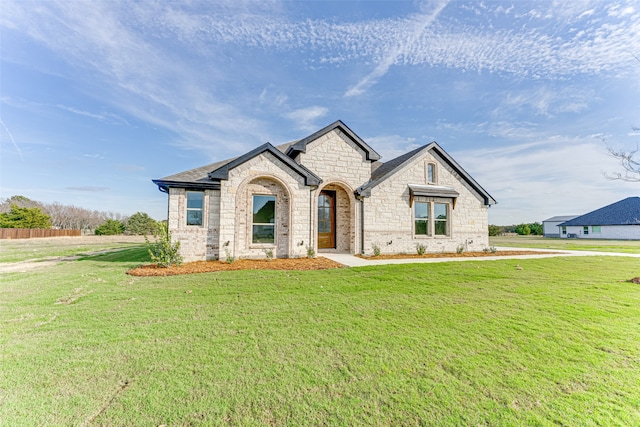 french country style house featuring a front yard