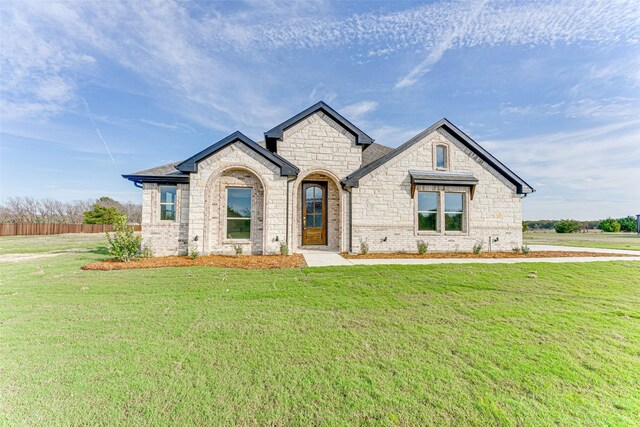 french country style house featuring a front yard