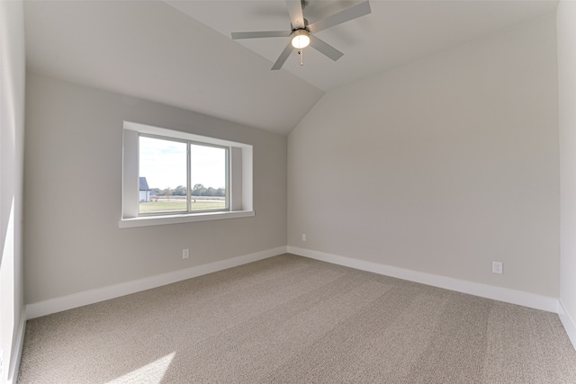 carpeted empty room with ceiling fan and vaulted ceiling