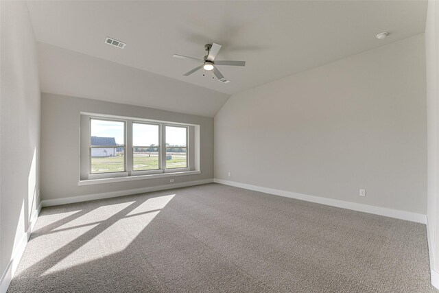 unfurnished room featuring ceiling fan, light carpet, and vaulted ceiling