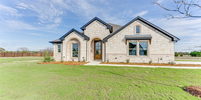 french country home with a front lawn