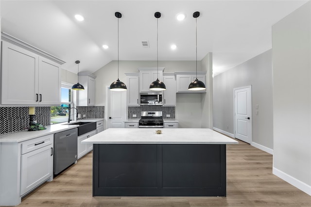 kitchen featuring white cabinetry, sink, stainless steel appliances, light hardwood / wood-style floors, and a kitchen island