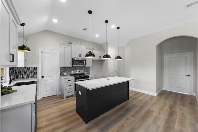 kitchen with white cabinets, light wood-type flooring, a center island, and stainless steel appliances