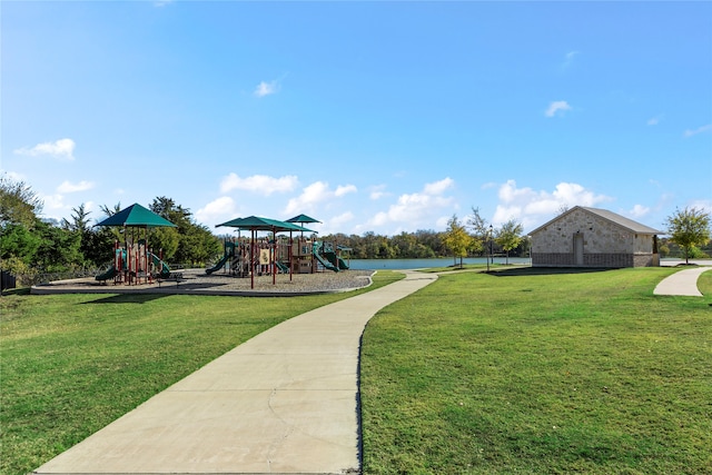 exterior space with a playground, a lawn, and a water view