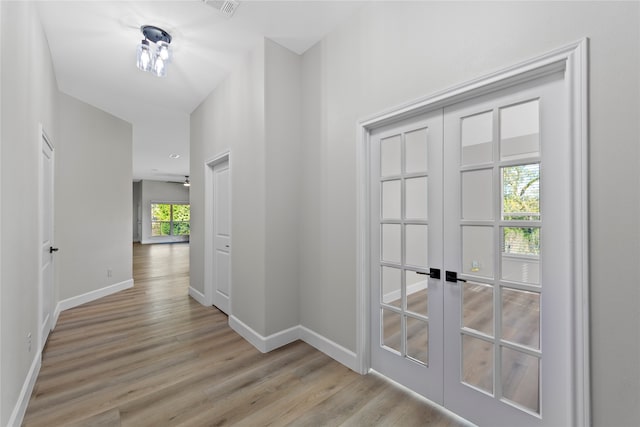 hallway featuring french doors and light wood-type flooring