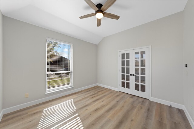 unfurnished room featuring ceiling fan, french doors, lofted ceiling, and light hardwood / wood-style flooring