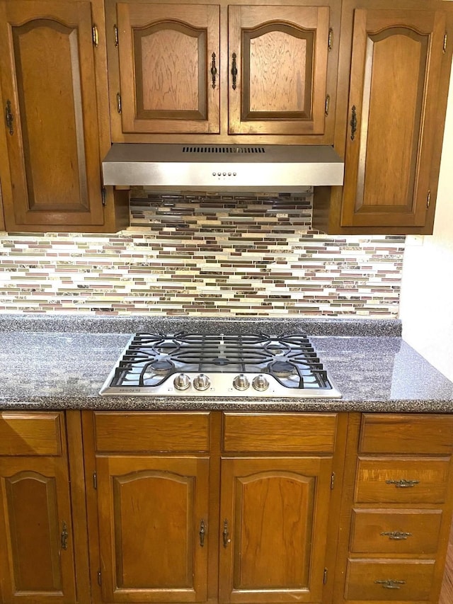 kitchen with stainless steel gas stovetop and backsplash