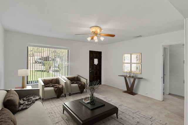 carpeted living room with ceiling fan