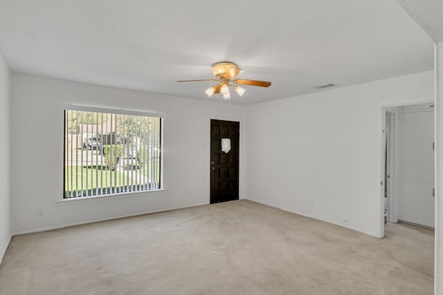 interior space with ceiling fan and light colored carpet