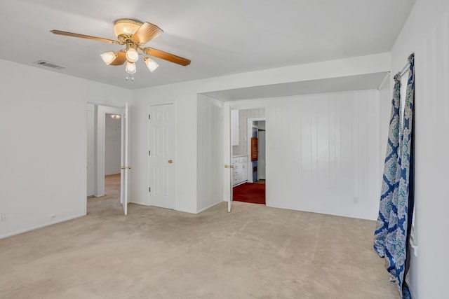 unfurnished bedroom featuring ceiling fan, a closet, and light carpet