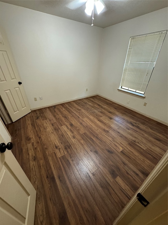 spare room featuring dark hardwood / wood-style floors and ceiling fan