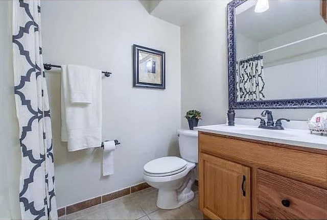 bathroom with toilet, vanity, and tile patterned floors