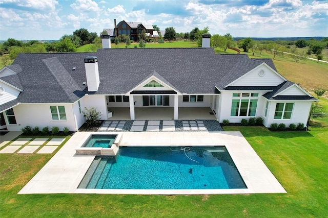 back of house with a pool with hot tub, a patio area, and a yard