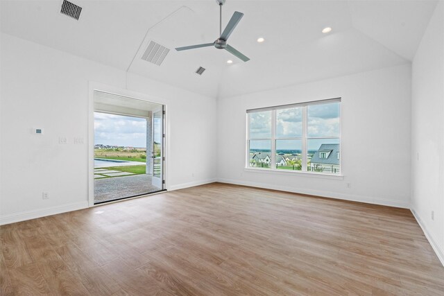 spare room with light hardwood / wood-style floors, vaulted ceiling, and ceiling fan