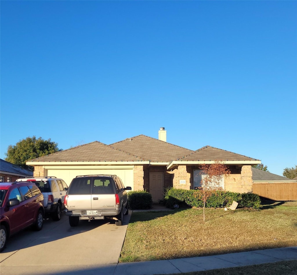 single story home featuring a garage and a front yard