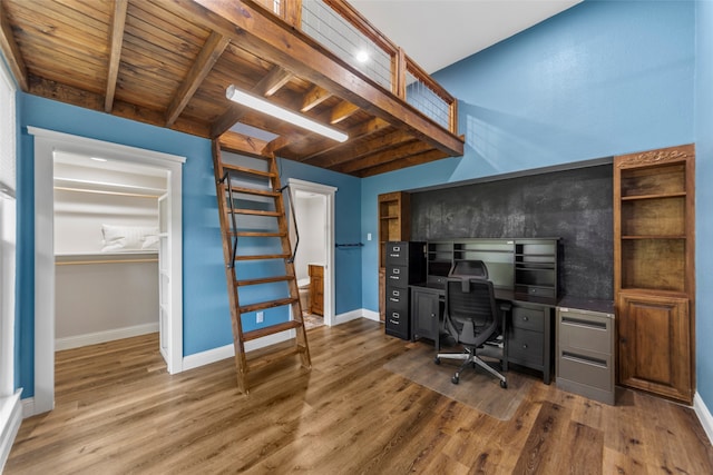 office with beam ceiling, dark wood-type flooring, and wood ceiling