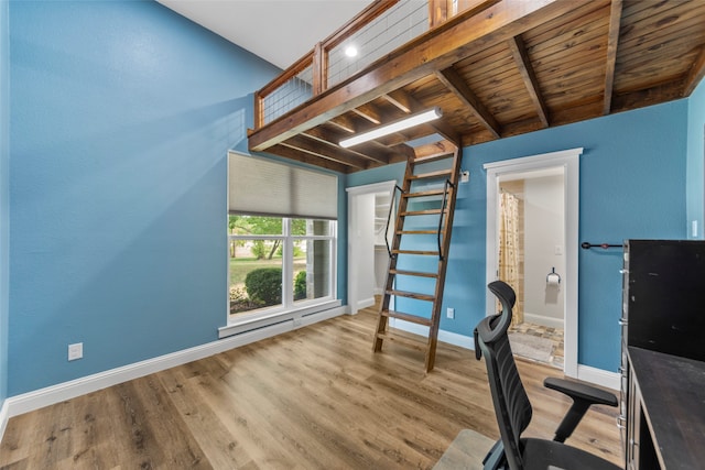 unfurnished office featuring wooden ceiling, beam ceiling, and light hardwood / wood-style flooring