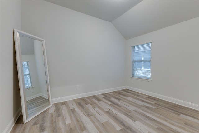 unfurnished room with light hardwood / wood-style floors and vaulted ceiling