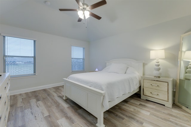 bedroom with ceiling fan, lofted ceiling, light wood-type flooring, and multiple windows