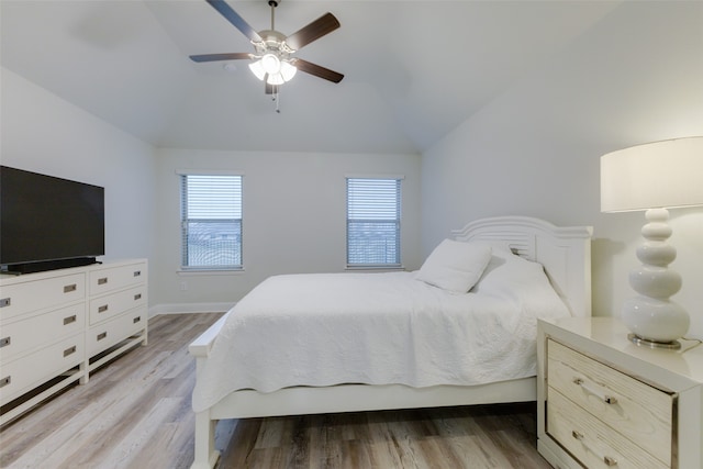 bedroom with ceiling fan, light wood-type flooring, and lofted ceiling