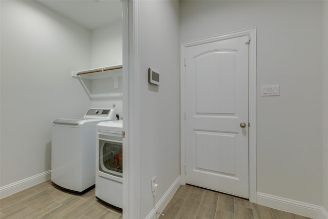 laundry room featuring light hardwood / wood-style floors and washer and clothes dryer