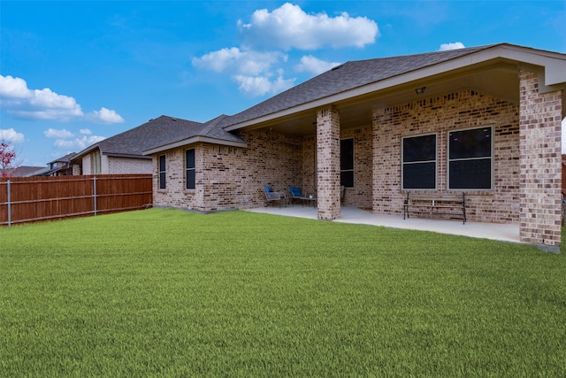 back of property featuring a patio area and a lawn