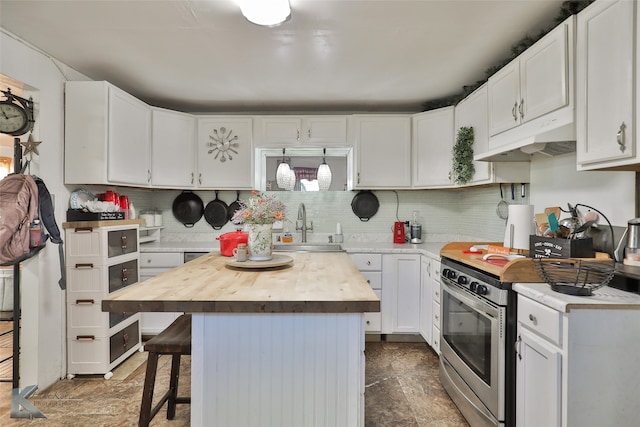 kitchen with white cabinetry, sink, a kitchen breakfast bar, stainless steel range with electric stovetop, and a kitchen island