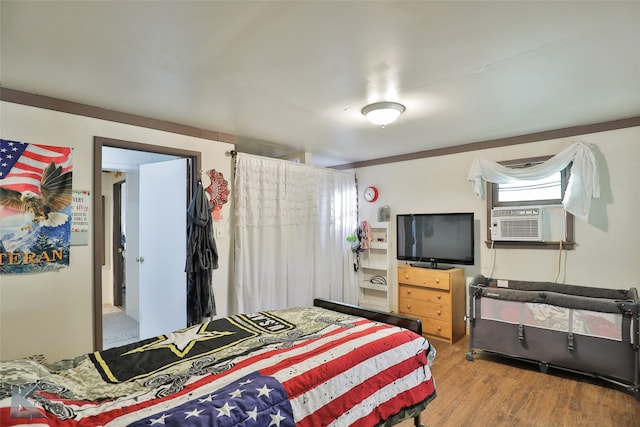 bedroom with cooling unit and wood-type flooring