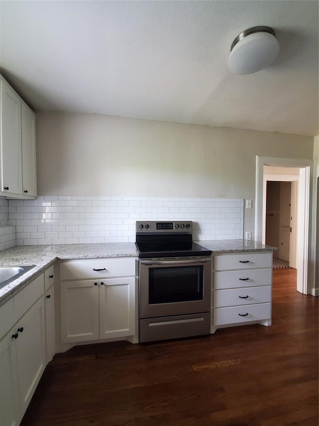 kitchen with stainless steel electric stove, light stone counters, white cabinets, and dark wood-type flooring