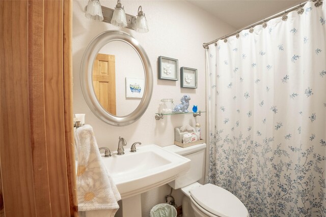 bathroom featuring curtained shower and toilet