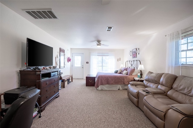 bedroom with light carpet, multiple windows, and ceiling fan